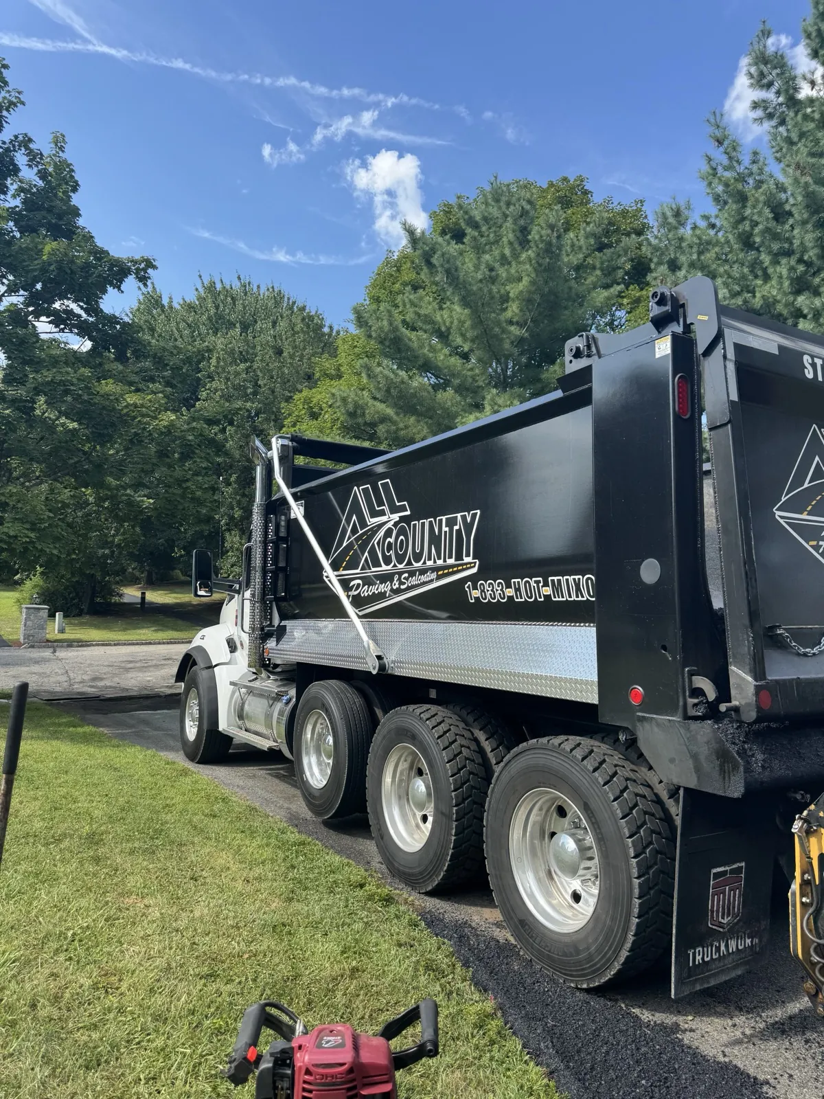 Branded All County Paving dump truck on a job site
