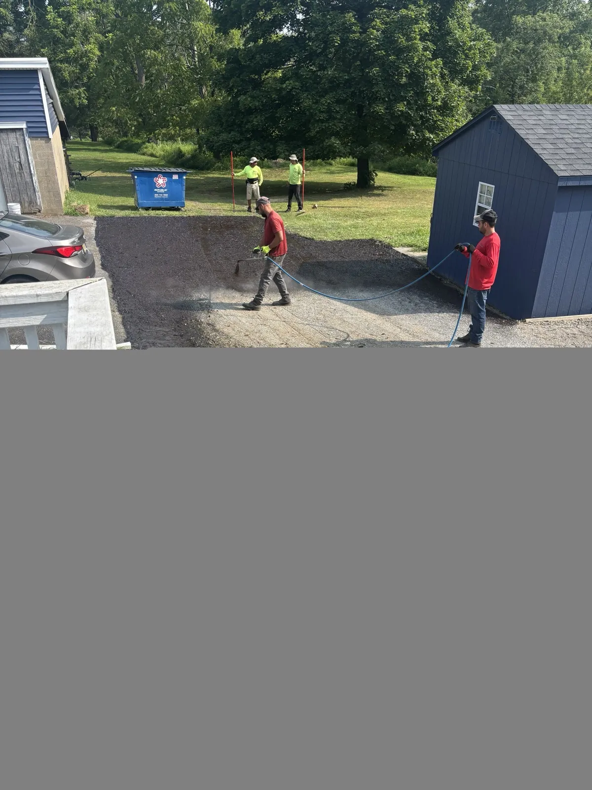 Crew applying sealcoat to an asphalt surface
