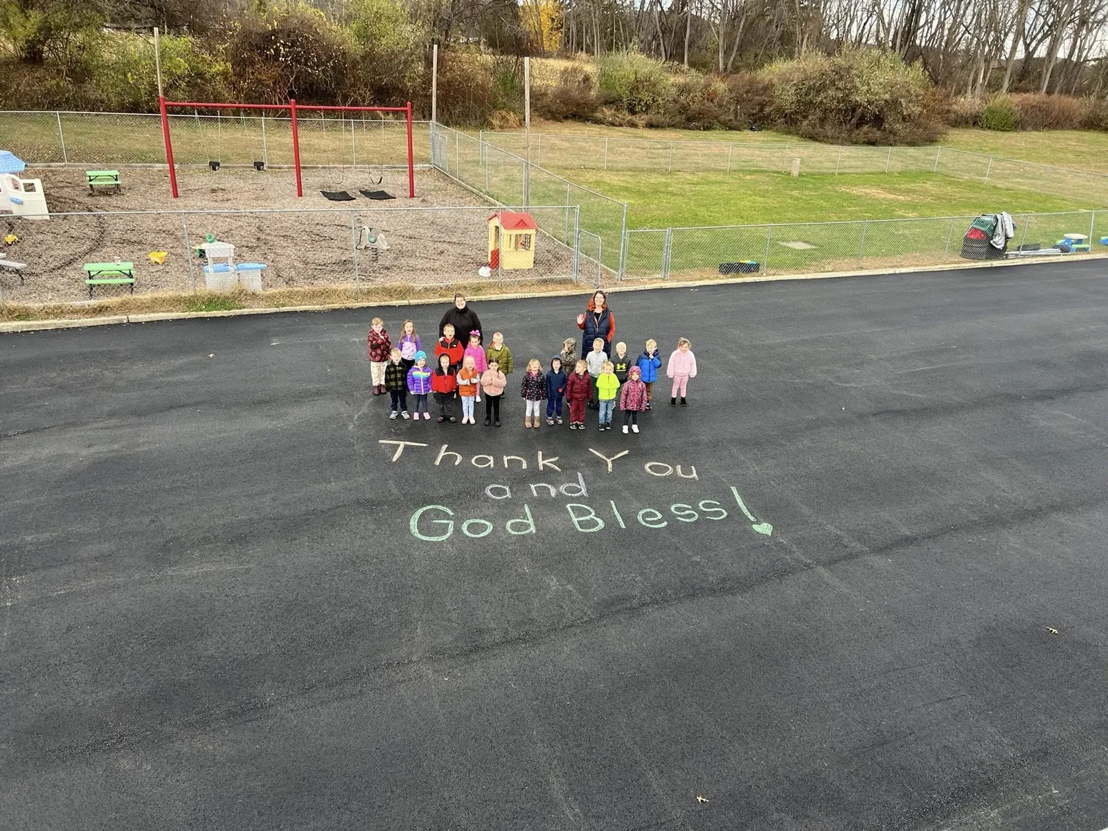 Naylor and the All County Paving crew on freshly paved asphalt with a hand-written thank you message