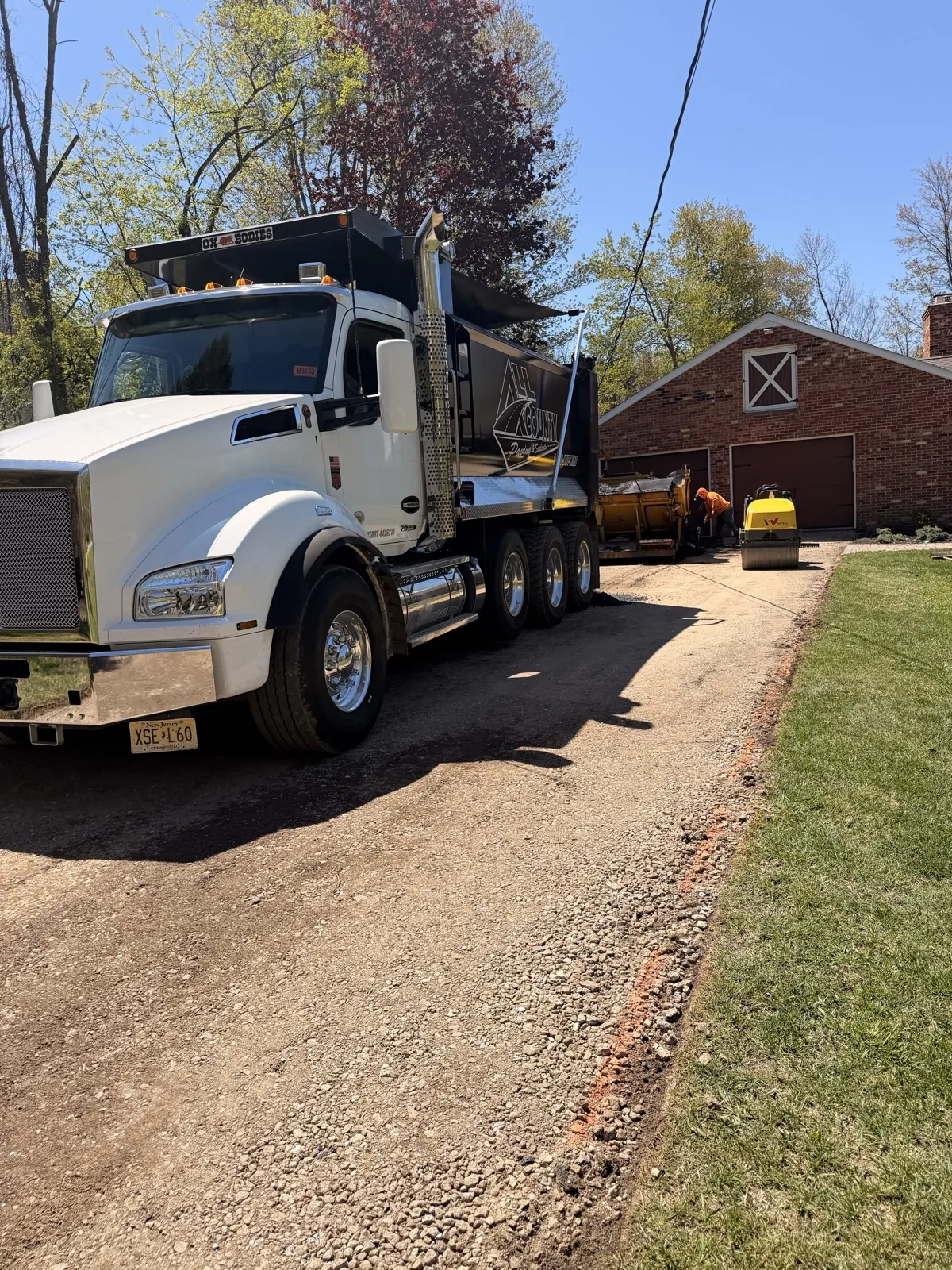 Branded All County Paving dump truck close-up showing logo and contact info