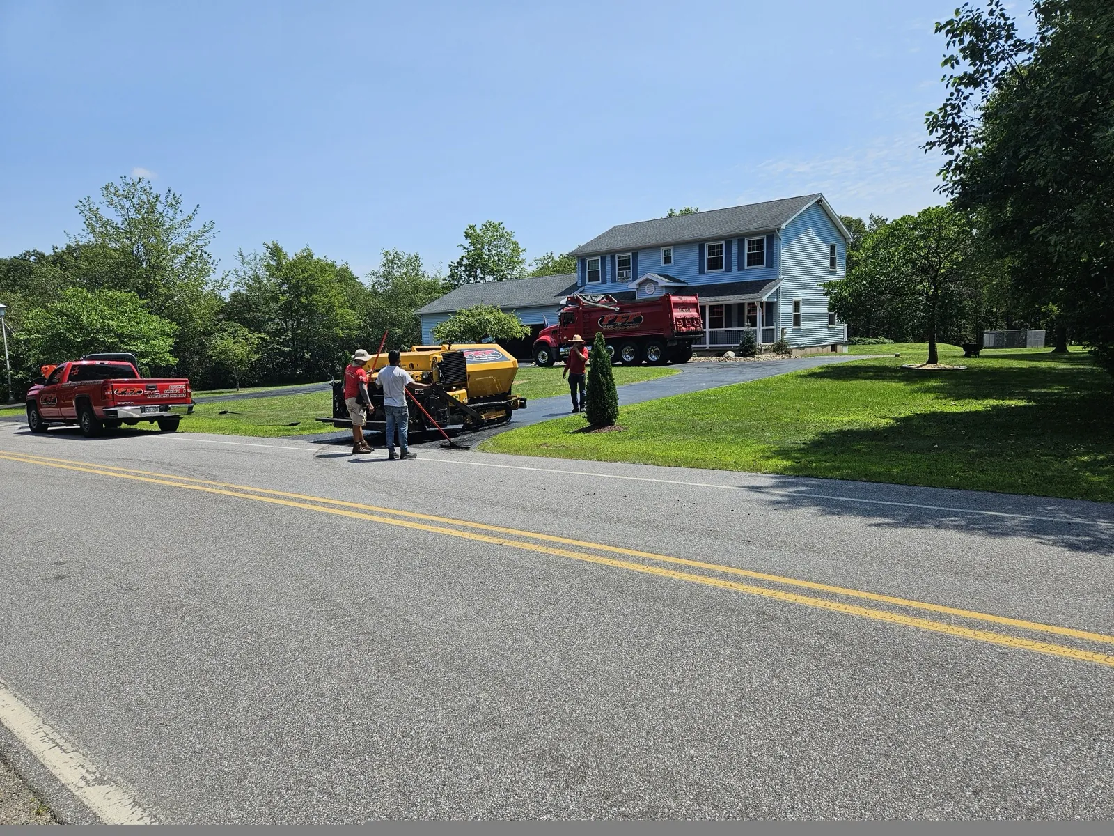 Multi-truck crew + paver on suburban street, All County Paving NJ and PA