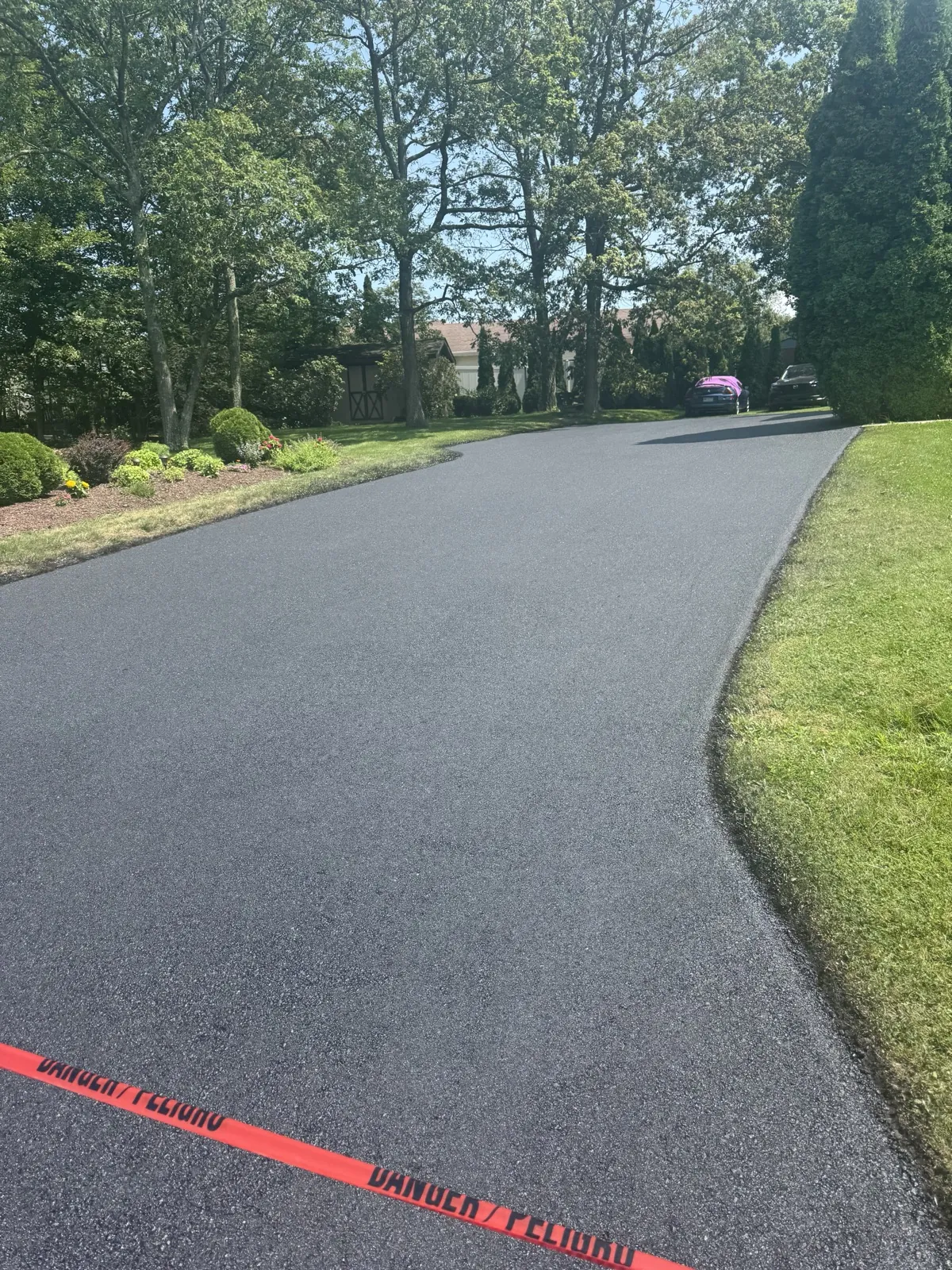 Asphalt driveway blocked off with safety tape during installation