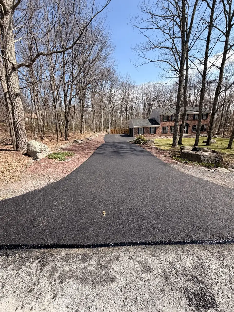 Driveway through the woods in daylight, paved by All County Paving in New Jersey
