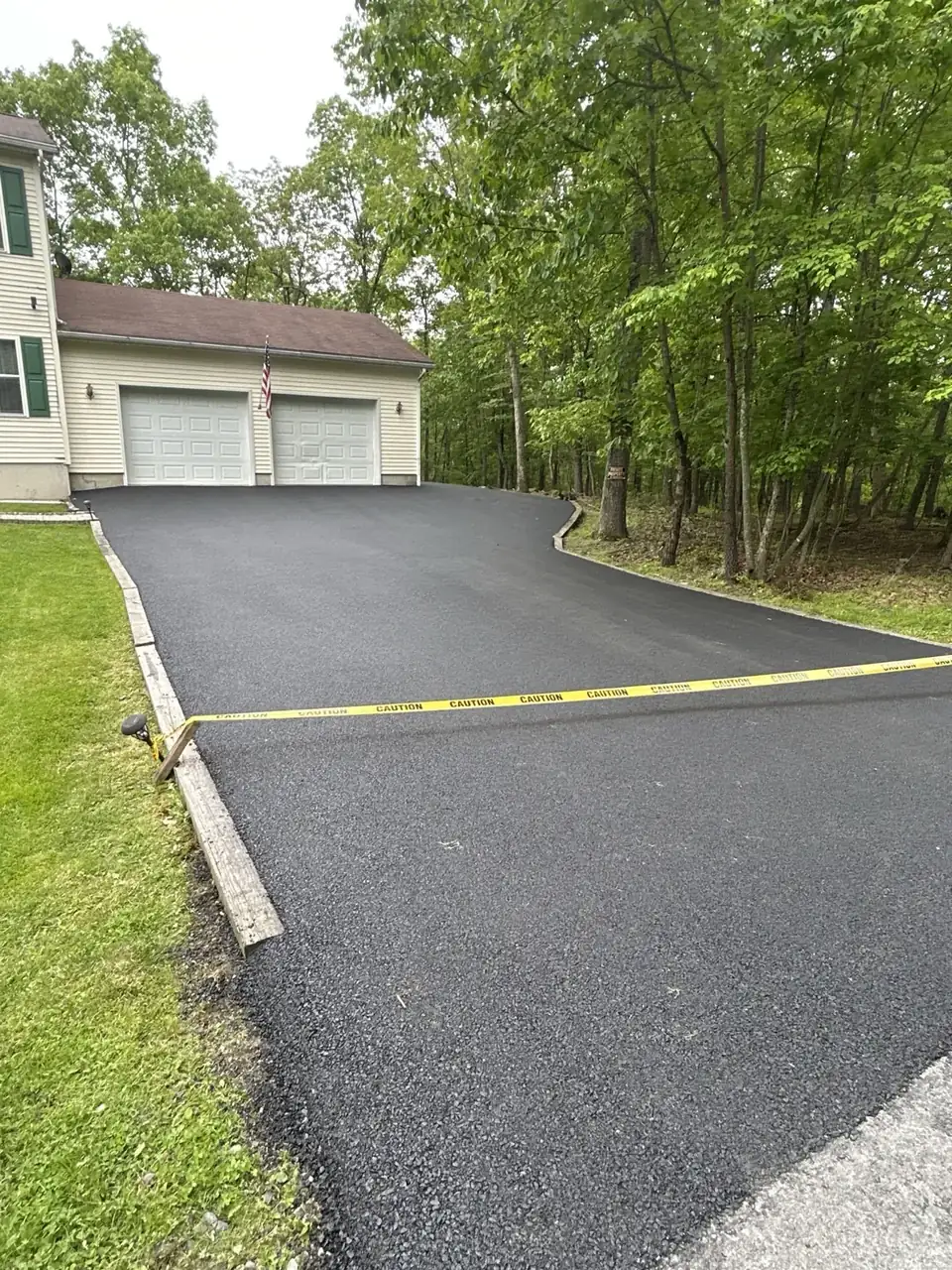 Wide driveway with green border, paved by All County Paving in New Jersey